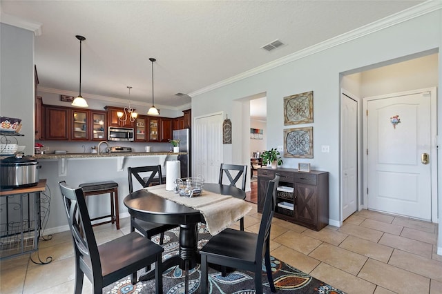 tiled dining space featuring a textured ceiling and crown molding