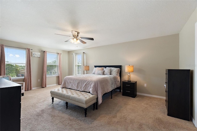 carpeted bedroom featuring ceiling fan and a textured ceiling