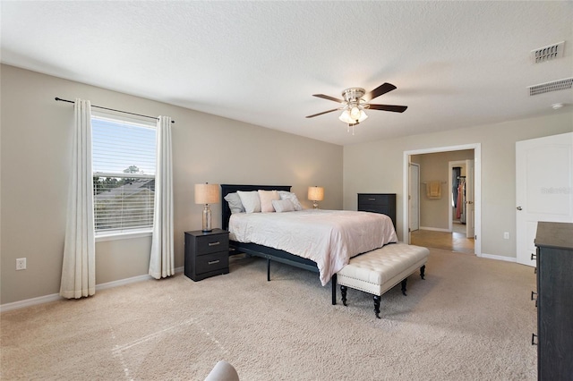 carpeted bedroom featuring ceiling fan and a textured ceiling