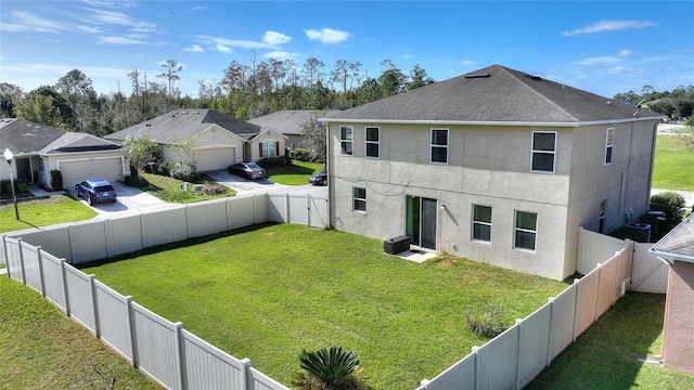 back of house with a lawn and a garage