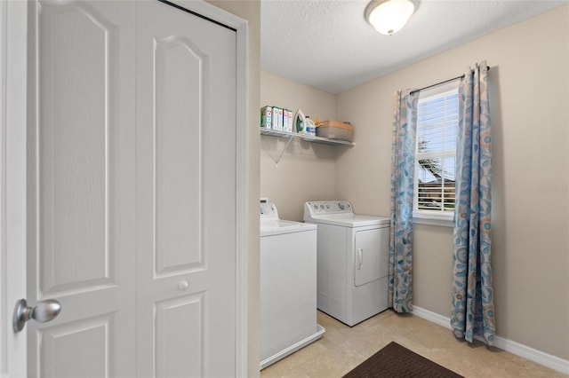 clothes washing area featuring a textured ceiling and washing machine and clothes dryer