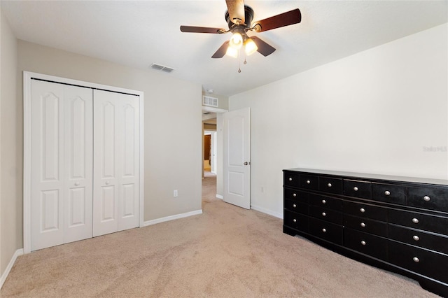 unfurnished bedroom featuring light colored carpet, a closet, and ceiling fan