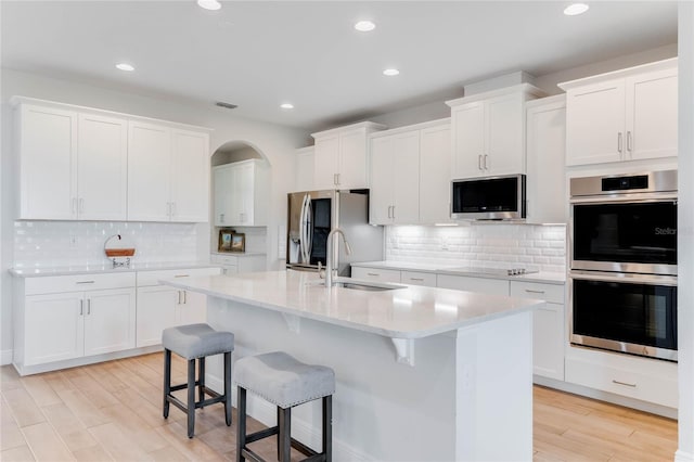 kitchen with white cabinets and an island with sink