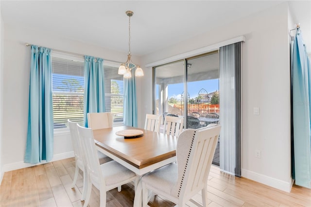 dining area with plenty of natural light, a notable chandelier, and light hardwood / wood-style flooring