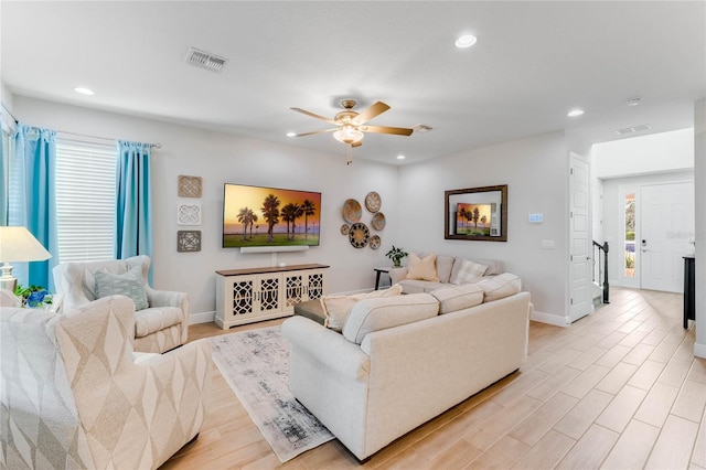 living room with ceiling fan, a wealth of natural light, and light hardwood / wood-style flooring