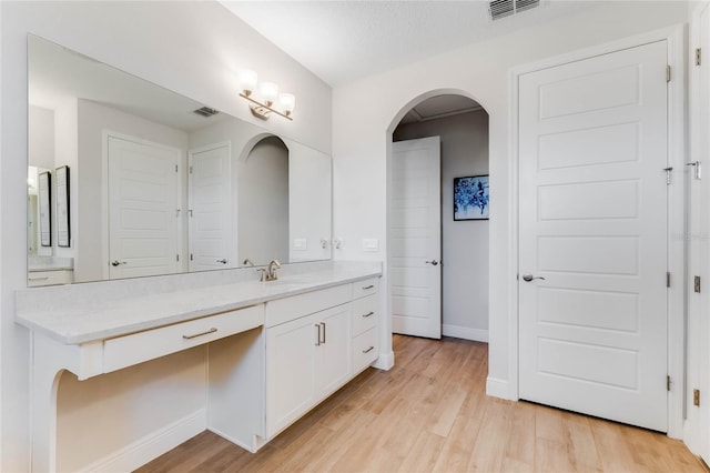 bathroom with wood-type flooring, vanity, and a textured ceiling