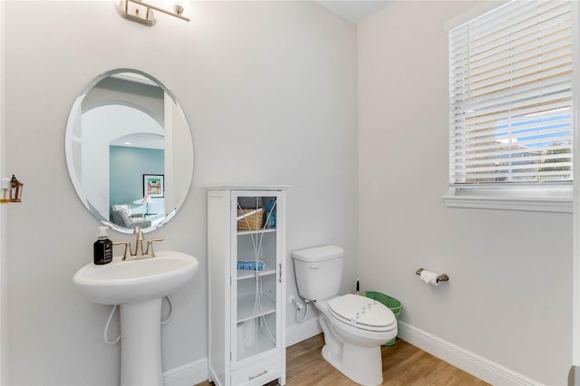 bathroom with hardwood / wood-style flooring and toilet