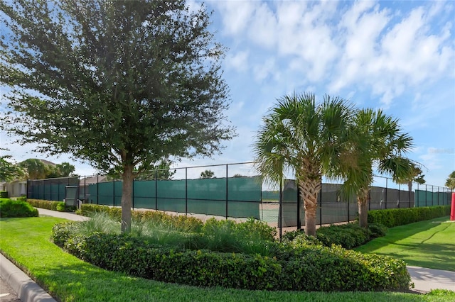 view of property's community with tennis court and a lawn