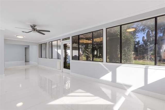 tiled spare room with a wealth of natural light, crown molding, and ceiling fan