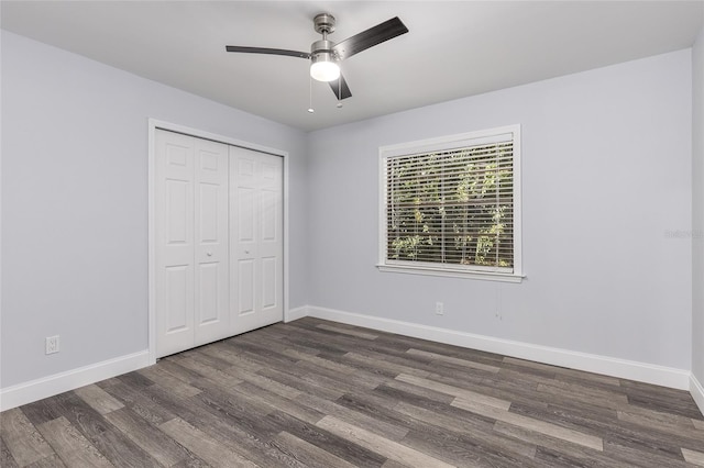 unfurnished bedroom featuring ceiling fan, dark hardwood / wood-style flooring, and a closet