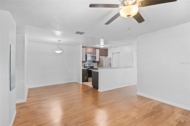 unfurnished living room with ceiling fan, light wood-type flooring, and a textured ceiling