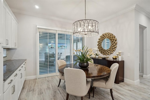 dining room with a chandelier, light wood-type flooring, and crown molding