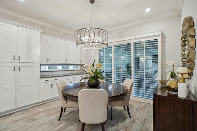 dining area featuring a notable chandelier, light hardwood / wood-style floors, and ornamental molding