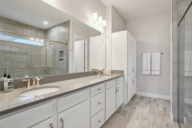 bathroom with walk in shower, vanity, and hardwood / wood-style flooring