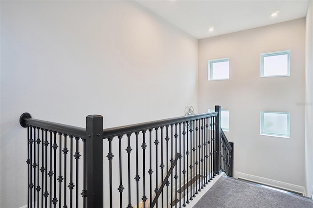 stairway featuring carpet flooring