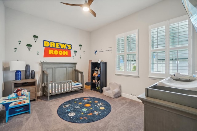 bedroom with ceiling fan, carpet, and a nursery area