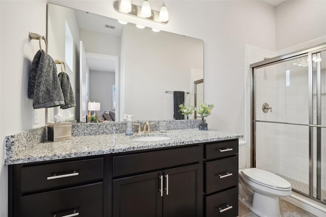 bathroom with tile patterned flooring, vanity, toilet, and a shower with door