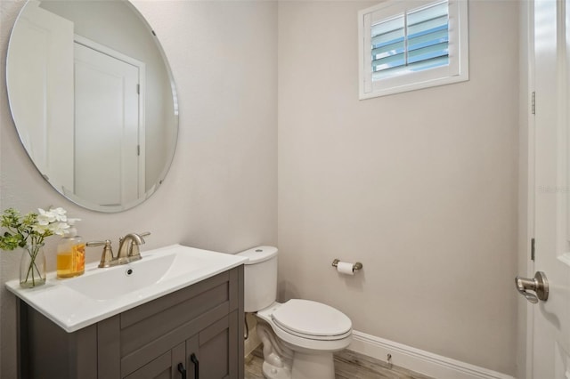 bathroom featuring hardwood / wood-style floors, vanity, and toilet