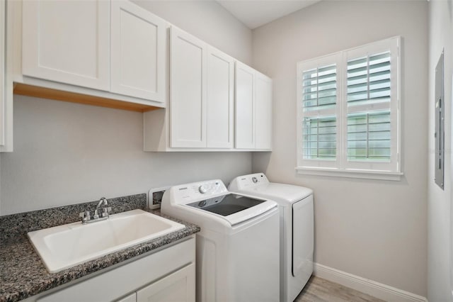 clothes washing area featuring light hardwood / wood-style floors, cabinets, independent washer and dryer, and sink