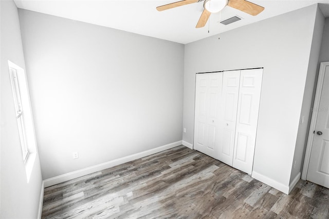 unfurnished bedroom featuring hardwood / wood-style flooring, ceiling fan, and a closet