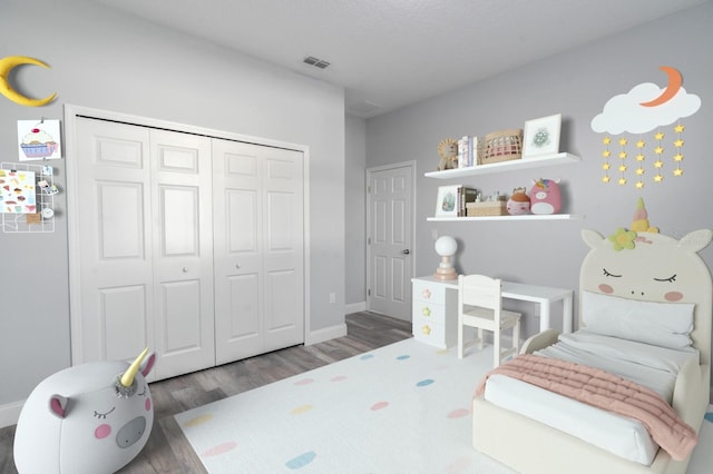 bedroom featuring a textured ceiling, dark wood-type flooring, and a closet