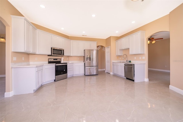 kitchen with appliances with stainless steel finishes, white cabinetry, ceiling fan, and sink