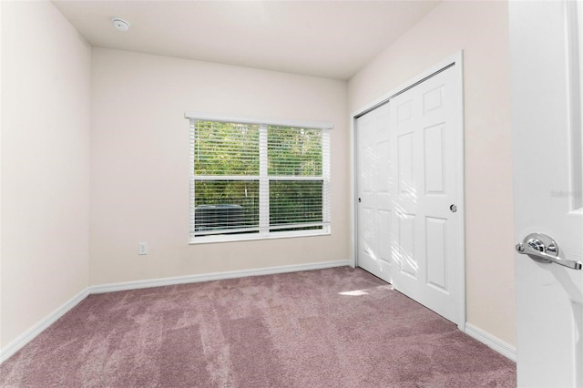 unfurnished bedroom with carpet flooring and a closet