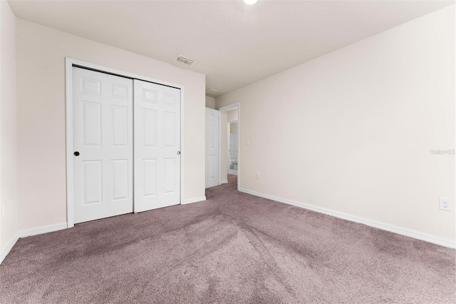 unfurnished bedroom with carpet floors and a closet