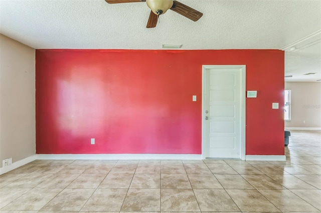 empty room with ceiling fan and a textured ceiling