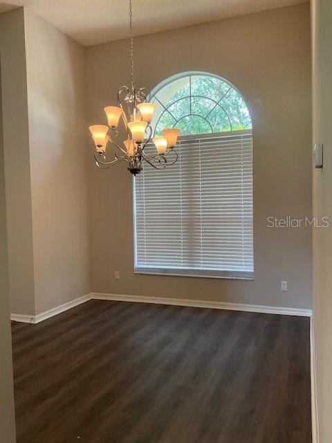 interior space with dark hardwood / wood-style flooring and a notable chandelier