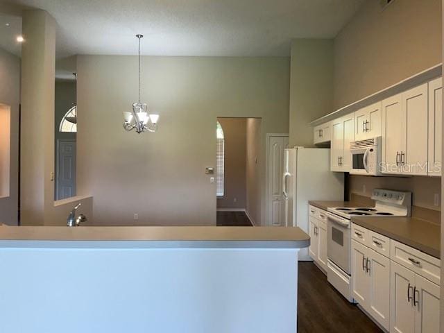 kitchen featuring white cabinetry, hanging light fixtures, white appliances, and a notable chandelier