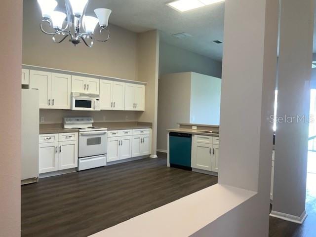 kitchen featuring white cabinetry, dark wood-type flooring, and white appliances