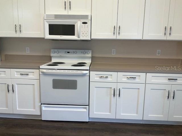 kitchen featuring white cabinets, dark hardwood / wood-style floors, and white appliances