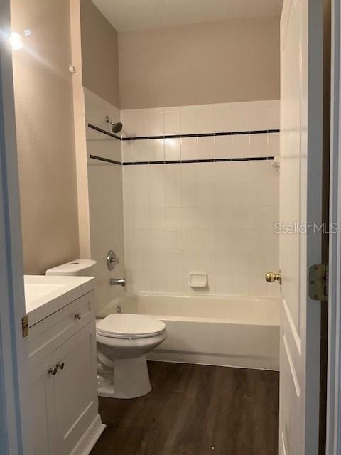 full bathroom featuring washtub / shower combination, wood-type flooring, vanity, and toilet