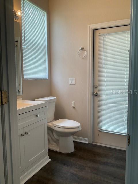 bathroom featuring hardwood / wood-style flooring, vanity, and toilet