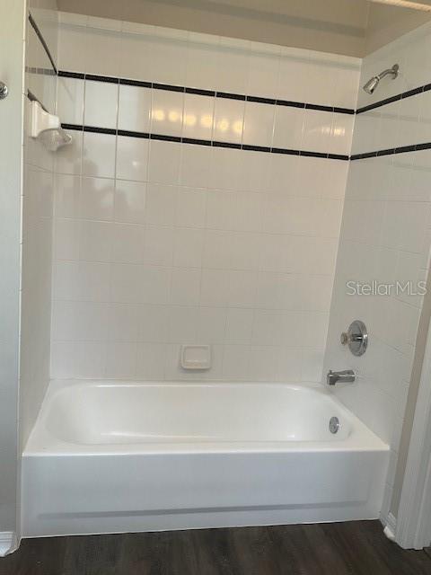 bathroom featuring hardwood / wood-style floors and tiled shower / bath combo