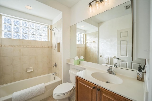 full bathroom featuring plenty of natural light, vanity, tiled shower / bath combo, and toilet