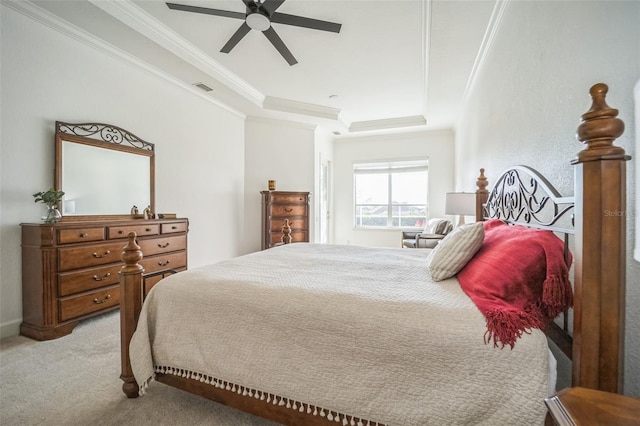 bedroom featuring a tray ceiling, ceiling fan, crown molding, and light carpet