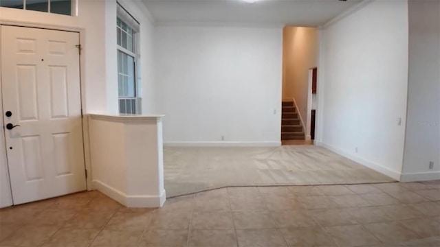 carpeted foyer entrance featuring ornamental molding