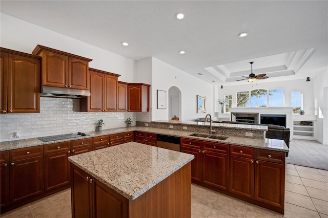 kitchen with black electric cooktop, light stone counters, sink, and a kitchen island