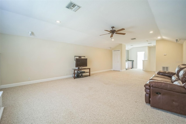 carpeted living room with ceiling fan and vaulted ceiling