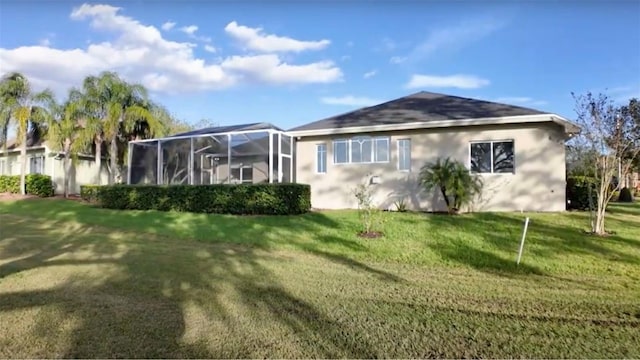 rear view of house featuring a yard and a lanai