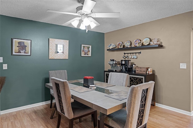 dining room with ceiling fan, a textured ceiling, and light wood-type flooring