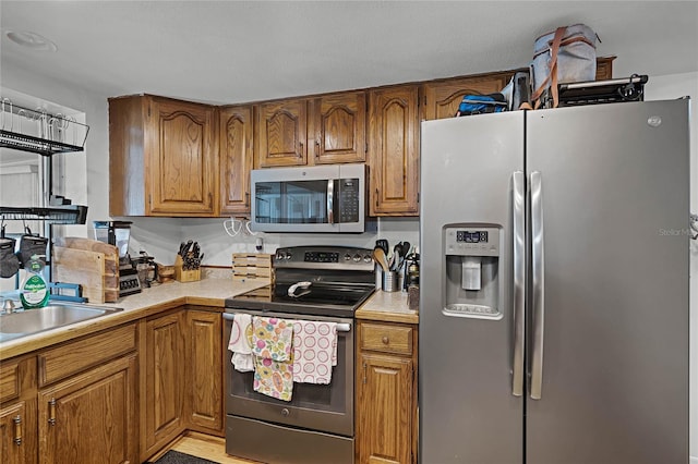 kitchen with sink, stainless steel appliances, and light wood-type flooring