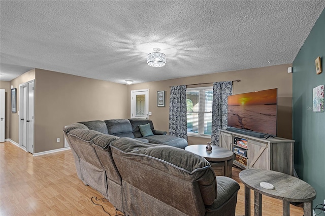 living room with light hardwood / wood-style flooring and a textured ceiling