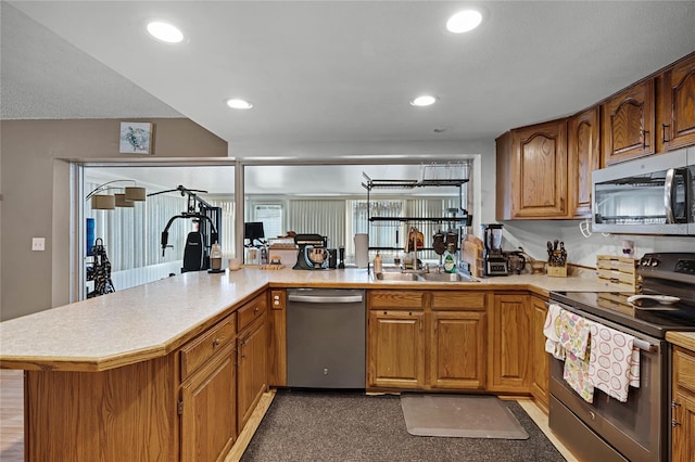 kitchen with kitchen peninsula, stainless steel appliances, and sink