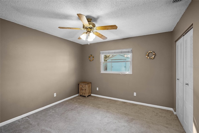 empty room featuring carpet, a textured ceiling, and ceiling fan