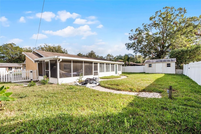 back of property featuring a sunroom, a shed, and a lawn