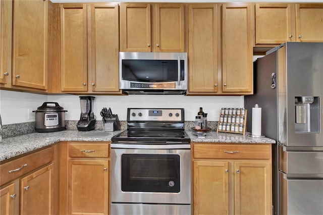 kitchen featuring light stone countertops and appliances with stainless steel finishes