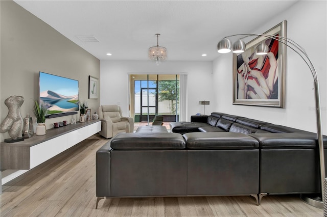 living room with light hardwood / wood-style flooring and a notable chandelier